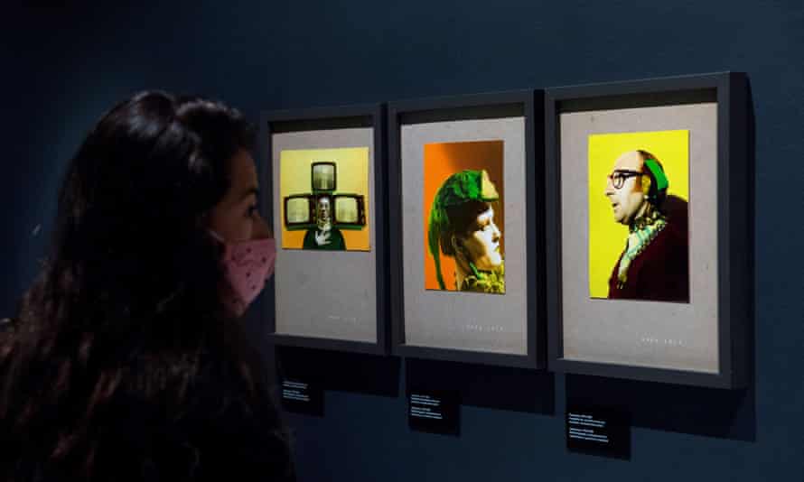 A masked person looks at artworks by Ouka Leele
