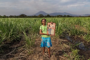 Sugarcane worker Maria Esther Ulloa Orozco holds up a picture of