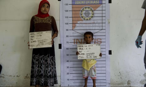 A Rohingya woman and a child from Burma are photographed during identification procedures at a newly set up confinement area in Aceh province in Indonesia after hundreds of migrants from Burma and Bangladesh were rescued by Indonesian fishermen off the waters of the province on 20 May.