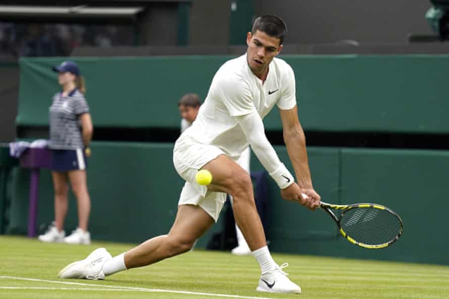 El español Carlos Alcaraz devuelve el balón al alemán Jan-Lennard Struff durante su partido individual masculino el primer día de Wimbledon.