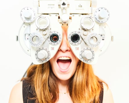 A young woman with a comically surprised expression having an eye exam