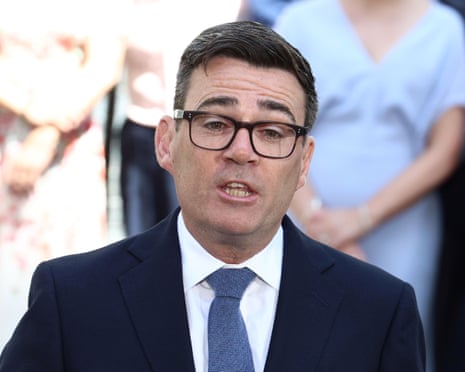 Andy Burnham in a dark suit and glasses speaks while standing outdoors