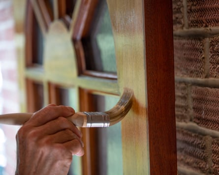 Man painting house front door with varnish, closeup on brush