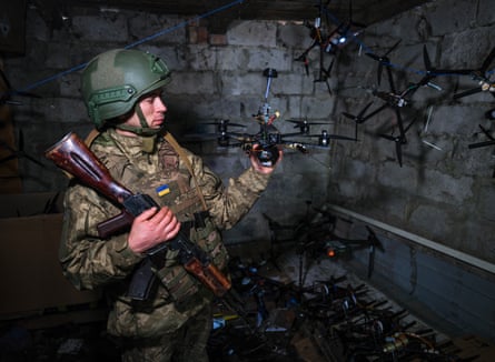 A Ukrainian soldier inspects a drone