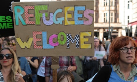 A child holds a placard saying 'refugees welcome' during a solidarity march in London.