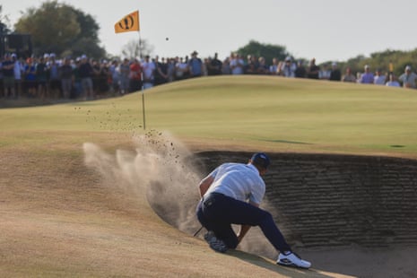 DeChambeau plays out of a bunker on the 14th.