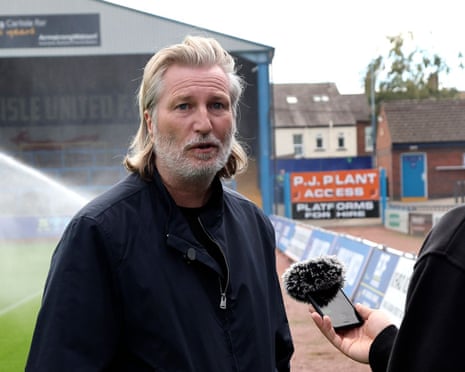 Robbie Savage talks to the media on the touchline at Brunton Park, Carlisle