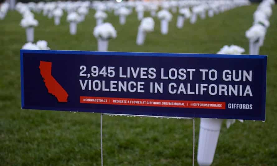 A sign at a memorial reads: 2,945 lives lost to gun violence in California.