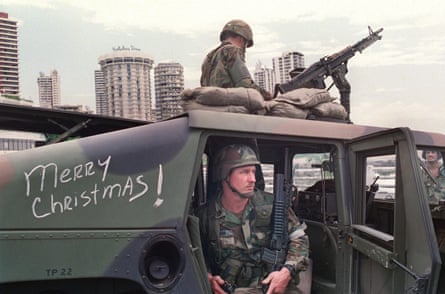 Two army soldiers on a tank, with the words Merry Christmas written in chalk on the side