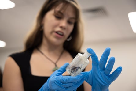 Student holding an old ink pot that still contains dried ink