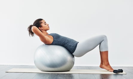 Shot of a young woman exercising using a fitness ball