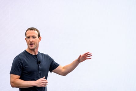 Марк Цукерберг, одягнений у темно-синю футболку на ґудзиках, жестикулює під час виступу на сцені