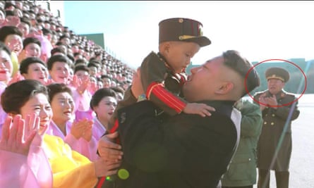 Dead or alive: Kim Jong-un holding a baby with defence minister Hyon Yong-chol circled in the background, who has been reported executed. 