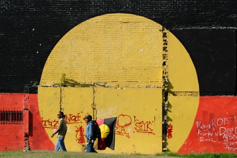 Two men walk past a wall in The Block in Redfern, home to the first urban Indigenous land rights claim in Australia.