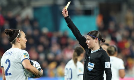 Lucy Bronze is shown a yellow card by referee Casey Reibelt.