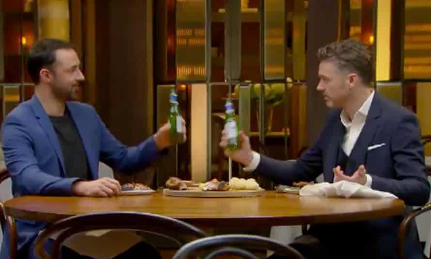 Two guys toast with bottles of beer