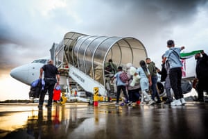 People board an airplane