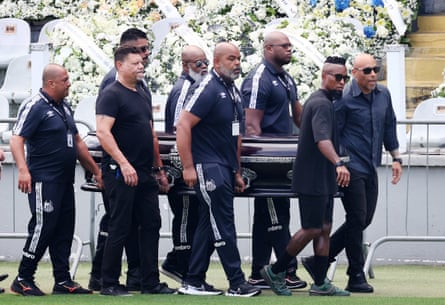 Pelé’s son Edinho (right) and former Brazil player Ze Roberto lead the coffin’s procession into the stadium.