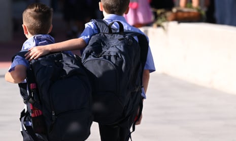 Two boys in uniform walk to school