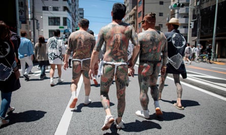 Participants with traditional Japanese tattoos, related to the Yakuza, walk through the Asakusa district during the annual Sanja Matsuri festival in Tokyo