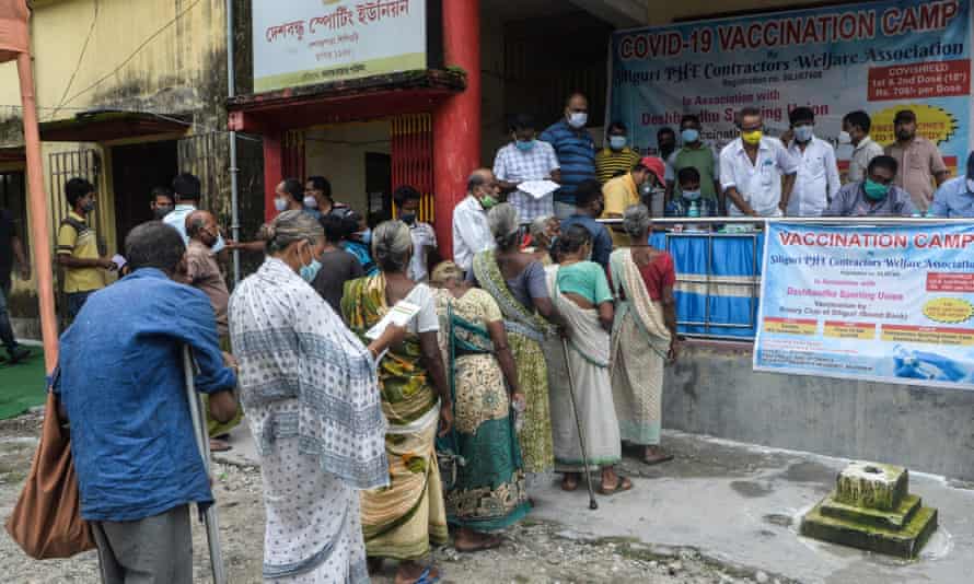 People stand in a queue as they wait to receive a dose of Covid vaccine in Siliguri, West Bengal, India.