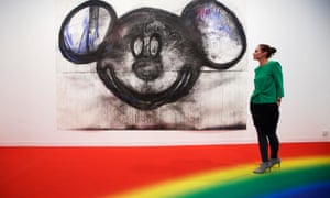 A visitor poses with artist Joyce Pensato’s Mickey for Micky at the 2014 Frieze Fair in London.