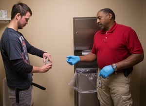 Charles “Bubba” Rouse handing a drug test cup filled with his urine to Drug Court Coordinator, Chris Brown