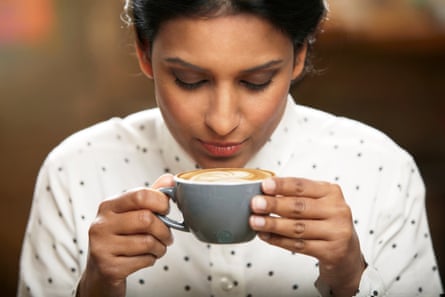 A woman about to drink a cup of coffee