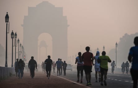 Joggers and walkers on a smoggy morning near the India Gate monument in New Delhi.