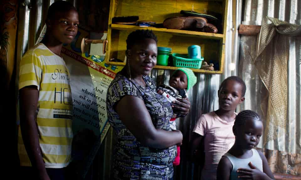 Faizun Omondi, 15, Cody Achieng with her baby Gary, Chelsea Dina, nine, and Denellythar June, eight, pose for a photograph at their home in the Kibera slum in Nairobi