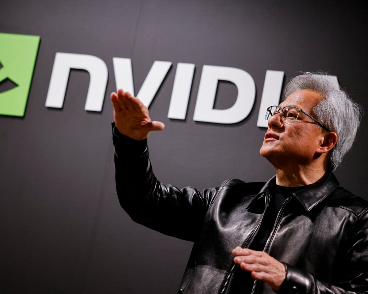 Nvidia CEO Jensen Huang gesturing in front of an Nvidia logo