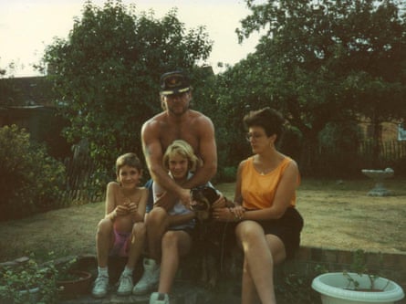 The family of four sitting together on a warm day in a back garden