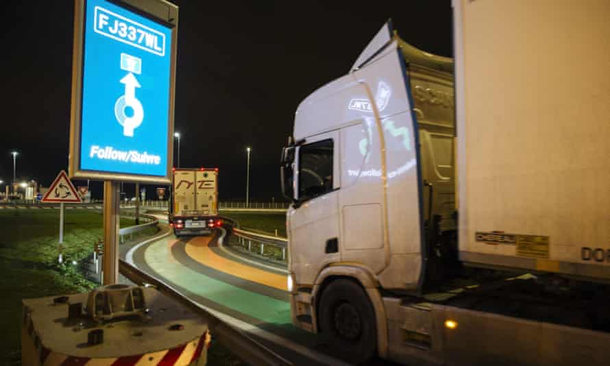 Sebuah truk dari Inggris melewati garis hijau dan oranye di jalan yang merupakan bagian dari infrastruktur pabean'perbatasan pintar' baru untuk memasuki Prancis di terminal Eurotunnel