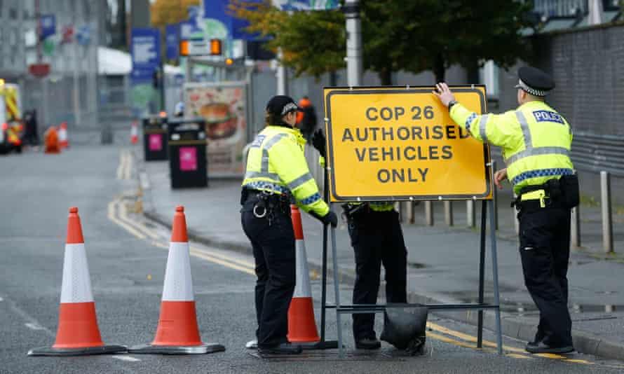 Police attempt to steady a road closure sign in strong winds