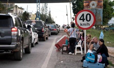 Migrants wait by the road in Pacaraima