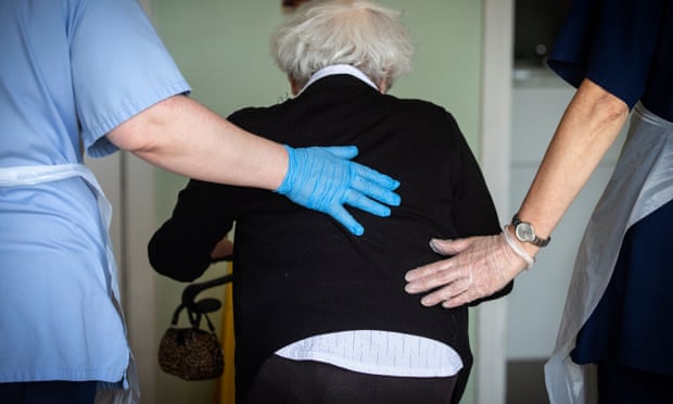 A resident is helped by care workers.