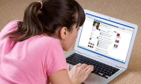 young woman looking at Facebook website on laptop computer.