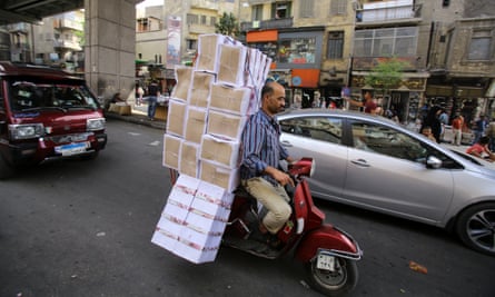 Chaotic … a man carries shoe boxes on a Vespa in downtown Cairo.