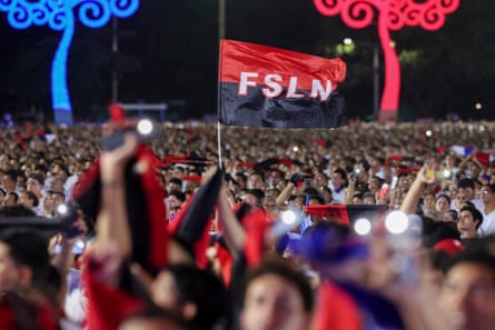 Large crowd of people waving red and black Sandinista flags