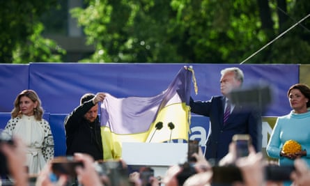 Volodymyr Zelenskiy and the Lithuanian president, Gitanas Nausėda, hold up a Ukrainian flag as Olena Zelenska and Diana Nausėdienė look on in Vilnius on Tuesday.