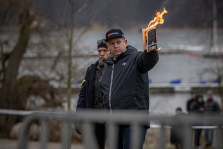 A man burning a copy of the Qu’ran.