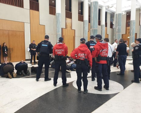Security and police surround protesters at Parliament House.
