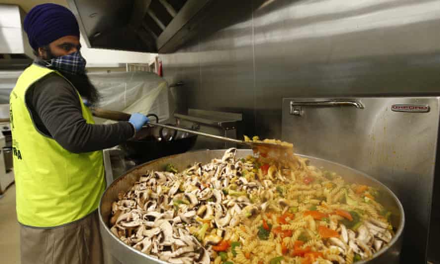 A volunteer stirs an enormous pot at a Sikh Volunteers Australia-run kitchen in Melbourne