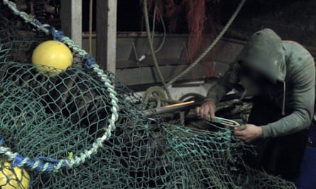 A worker mends nets on an Irish trawler