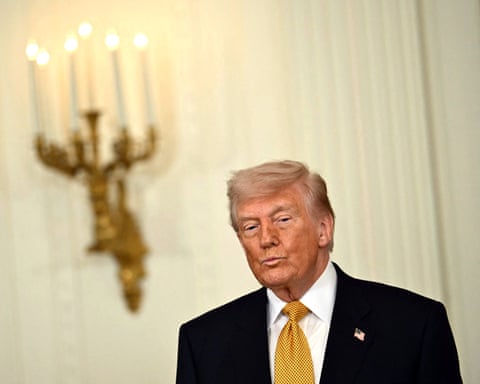 Donald Trump in a white-paneled room with gold trim.