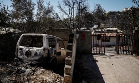 A burned out car outside a house