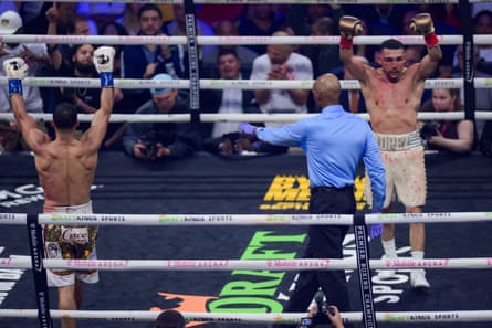 Both fighters raise their arms in victory after the final bell.