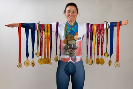 Sarah Storey poses in 2024 with her 28 Paralympic medals hanging off her arms
