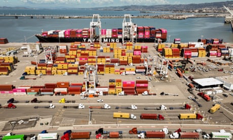 A ship is docked with cargo as trucks stand by