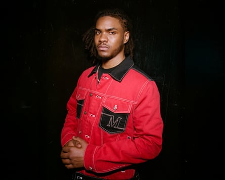 The rapper Pozer standing against a black background